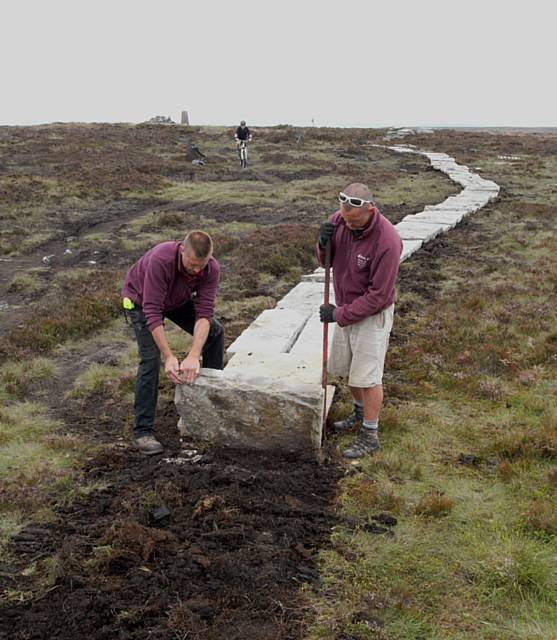 The re-surfacing work has included the laying of causey paving (stone slabs) which effectively narrows the path, and therefore the corridor of possible erosion and disturbance, and raise the walkway above the peat so that the layers underneath are protected. Once the paving is established, heather and other species will grow around and up through cracks in the paving