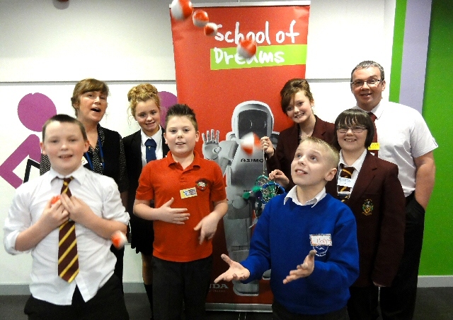 It shows students from Siddal Moor Sports College, Heap Bridge Primary School, St Luke’s C of E Primary School and Holy Family RC and C of E College with Wendy Hobson (right), Cluster Co-ordinator at Siddal Moor Sports College and Darren Walker (left), from Swansway Honda