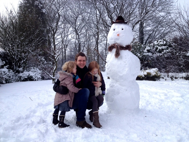 Ross Cunningham with Ruby, 3 and Skye, 6, and their snowman in Bamford