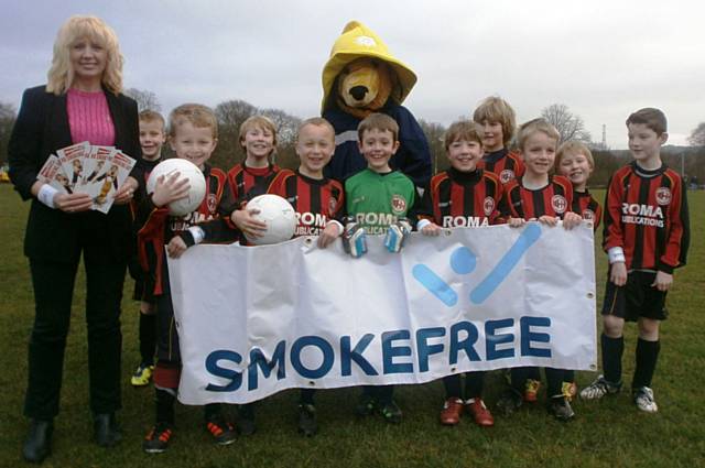 The under 8s Pennine Juniors players alongside Ve Nutter, Health Improvement Officer at Rochdale Borough Council, and Blaze Bear, the Fire Brigade Mascot