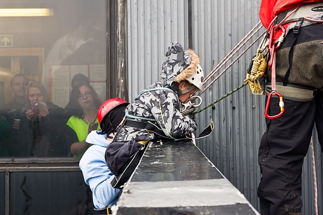 Adam Kutereba goes over the edge of the top of the black box ready for his 230 foot abseil - Adam's mum Rachel can be seen looking through the window camera in hand