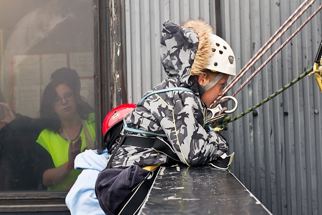 Adam Kutereba goes over the edge of the top of the black box ready for his 230 foot abseil