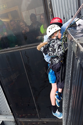 Adam Kutereba dangles over the edge at the top of the black box ready at the start of his 230 foot abseil