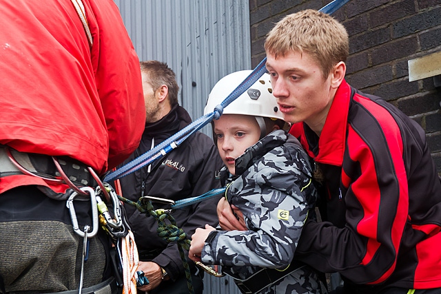 Adam Kutereba helmet and harness on is lifted onto the edge of the top of the black box 