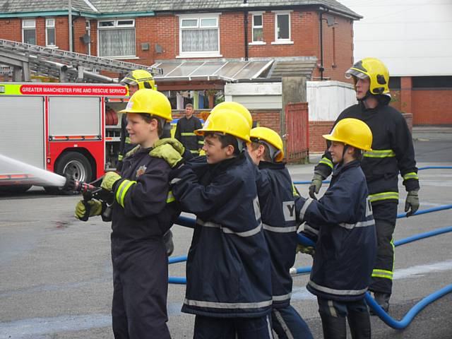 Young people perform fire and rescue demonstrations for their families at a passing out parade after completing an anti-social behaviour course at Rochdale Fire Station over the school holidays