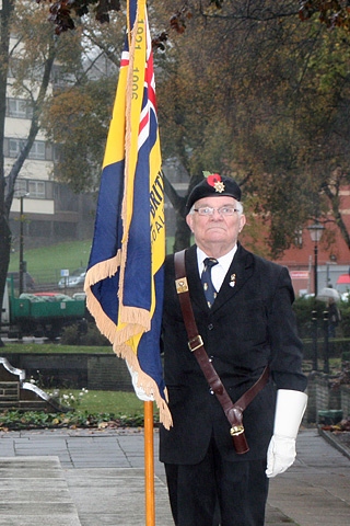 A retired serviceman holding his regiment flag