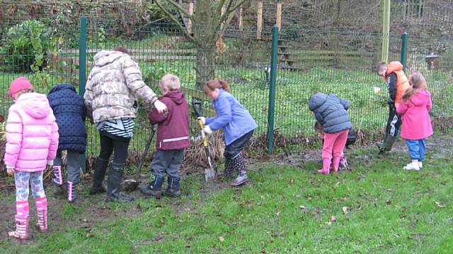 Class 3 at St John with St Michael CE Primary School digging in mud and planting tiny tree saplings donated from the Woodlands Trust