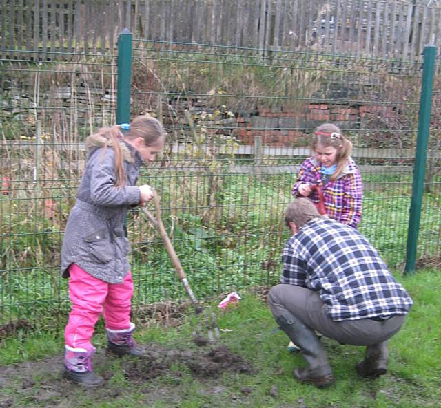 Class 3 at St John with St Michael CE Primary School with Mr Holmes, a gardener, explaining how to plant the tree saplings 