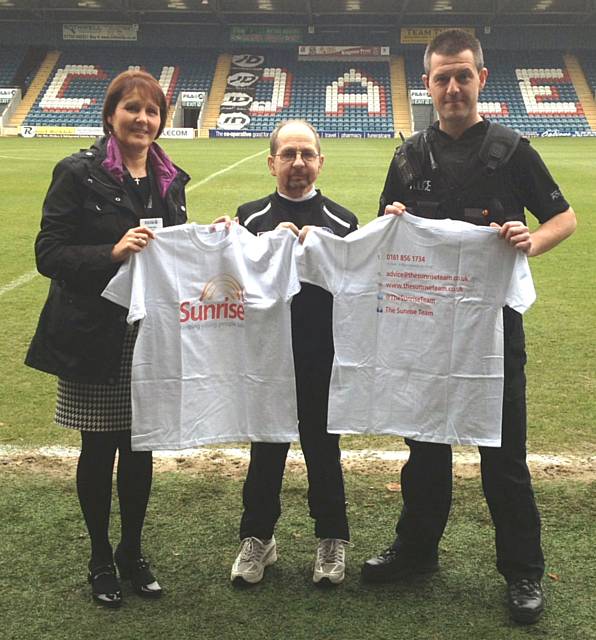 Crime Prevention Officer Jacqui Bell and PC Nathan McLean, present Sunrise Team T—Shirts to Rochdale AFC kitman Jack Northover