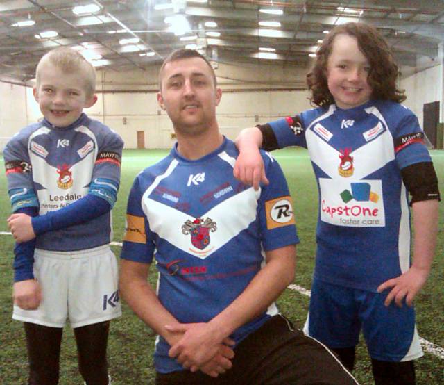 Pictured in their new kits are Jamie Howe of the Leedale Painters and Decorators sponsored Under 7s, John Marsland in the new Mayfield first team strip sponsored by Inten Property Maintenence, KOKO Lounge and Rentruck and Ben Wilkinson of the Capstone Foster Care sponsored under 8s