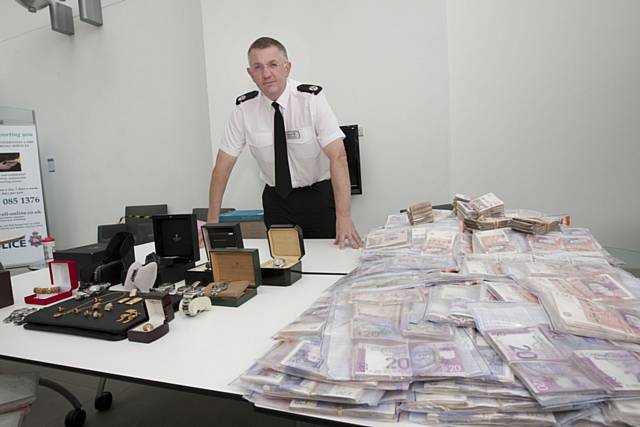 ACC Steve Heywood with the recovered nearly £7 million from criminals