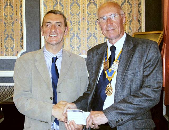 David Smithard, President of Rochdale Rotary Club presents a cheque Denis Skelton, Coordinator for the Rochdale Petrus Community Charity