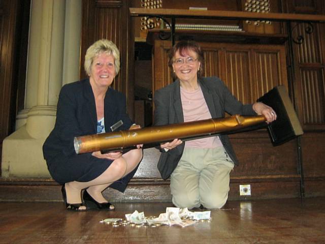 Town Hall manager Dorothy Johnstone and Alyson Brailsford emptying an old organ pipe used to collect donations