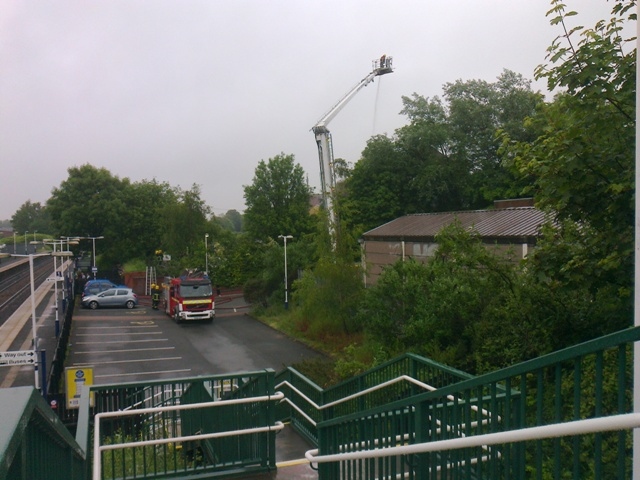 Fire-fighters wearing masks and using a fully extended ladder to fight the blaze