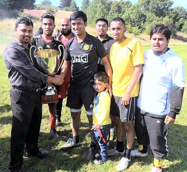 Doulat Miah, WCCA Manager, presents the trophy to the winning team, Return of Gaza FC 