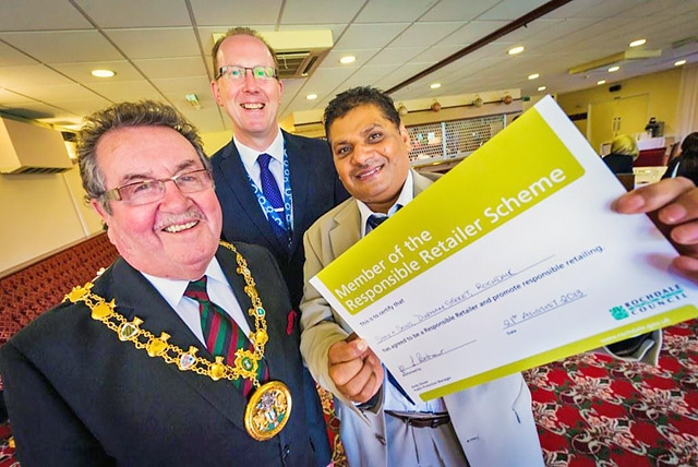 The Mayor, Councillor Peter Rush, Service Director for Economy and Environment at Rochdale Borough Council, Mark Widdup and Responsible Retailer Salamet Ali Khan, owner of Sam Sons, Durham Street, Rochdale