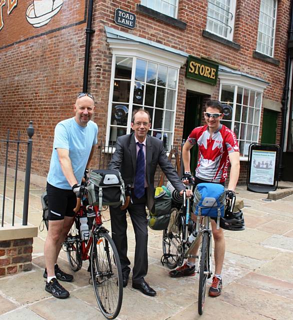 Andre Martin (left) and his son Charles set off from the Co-Operative Museum on Toad Lane in Rochdale on a 5,500 kilometre cycle ride after saying goodbye to Council Leader Colin Lambert