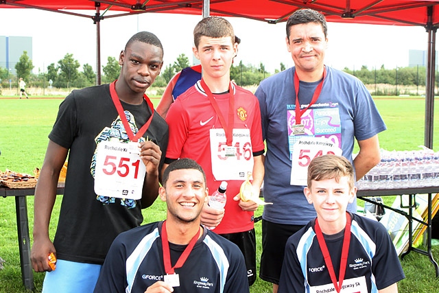 Runners in the 5K race show off their medals