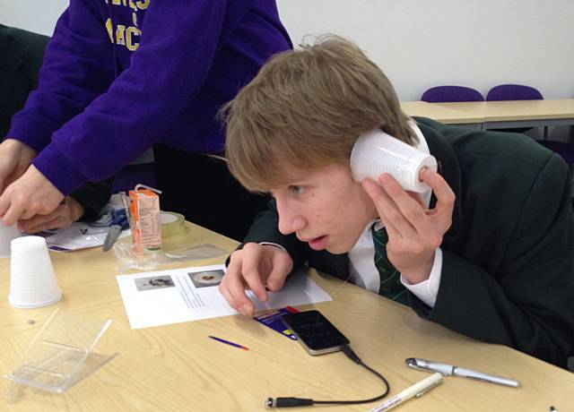 Wardle Academy student building his own set of headphones using a magnet, copper wire, paper cup and an audio socket