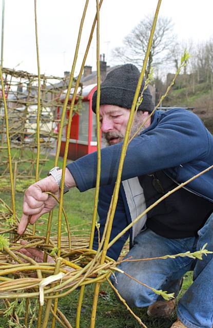 Ex-serviceman David Joddrell creating the living sculpture of a First World War tank from willow on the main road at Healey Corner 