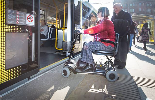 Sheila Rawcliffe boards a Metrolink tram on her approved mobility scooter using her new permit