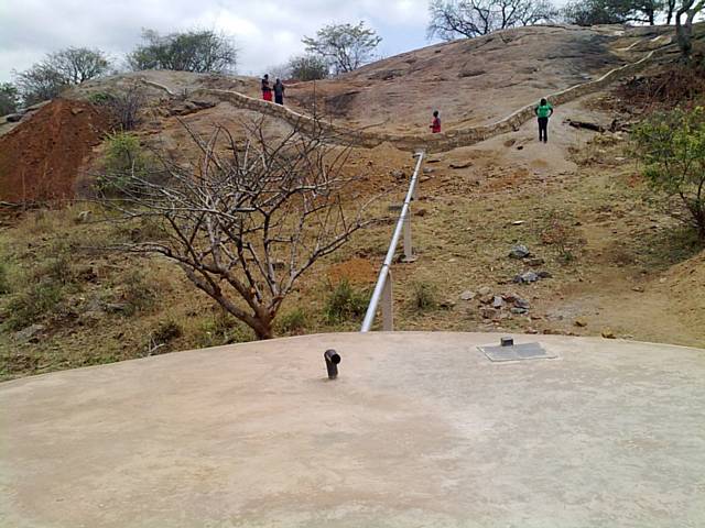 The rocky outcrop with the low wall around it to collect water and 225,000 litre tank