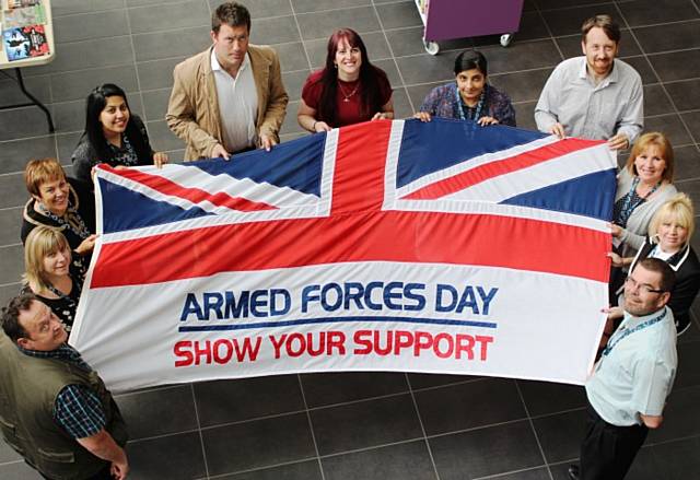 The council’s Acting Chief Executive Linda Fisher with Harry Scrope a retired Major in the Coldstream Guards and staff with one of the flags that will be raised across the borough on the run up to national Armed Forces Day