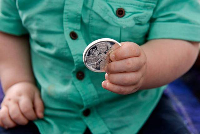 One-year-old Theo Walsh shares his birthday with Prince George receives a limited edition £5 coin from the Royal Mint to mark the joint birthday