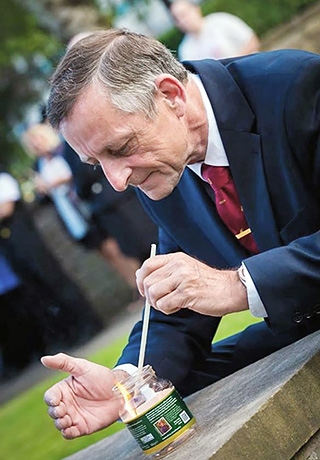 Councillor Alan McCarthy lights a candle