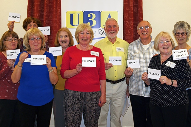 The Littleborough U3A committee hold up the interest group cards