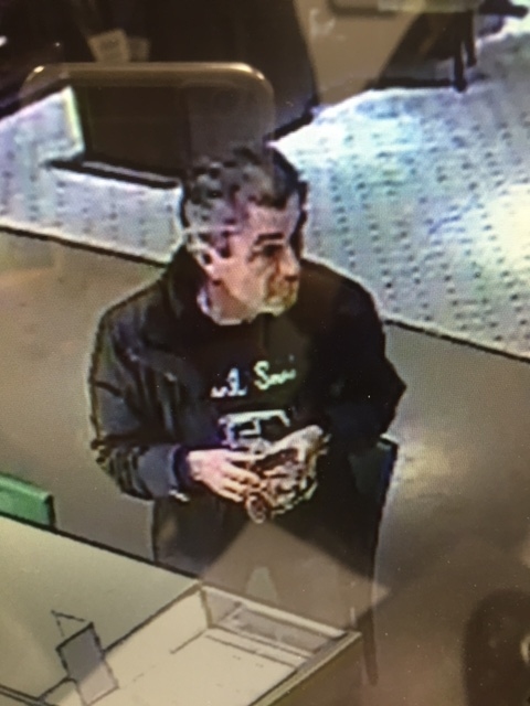 CCTV image of a man police wish to speak to in connection with a string of high-value frauds