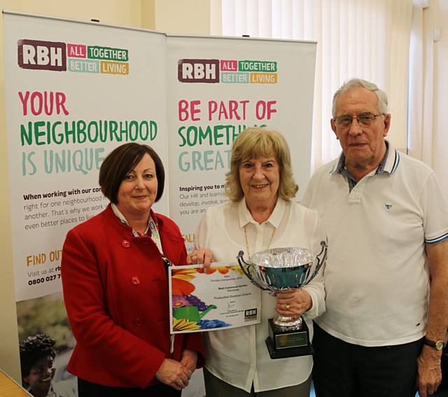 Kitty Hall (centre) and Brian Mulligan receive the cup from Caroline Goodall, who was a member of the judging panel