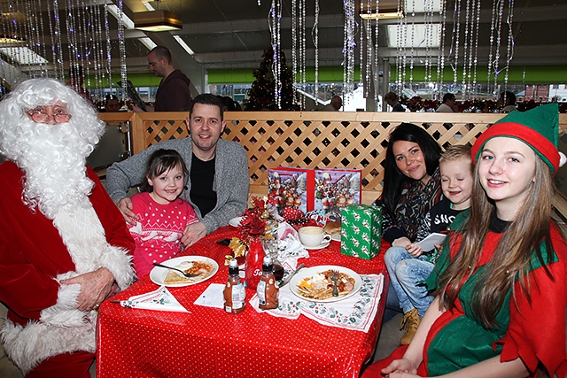 The Thomas Family with Santa and his Elf