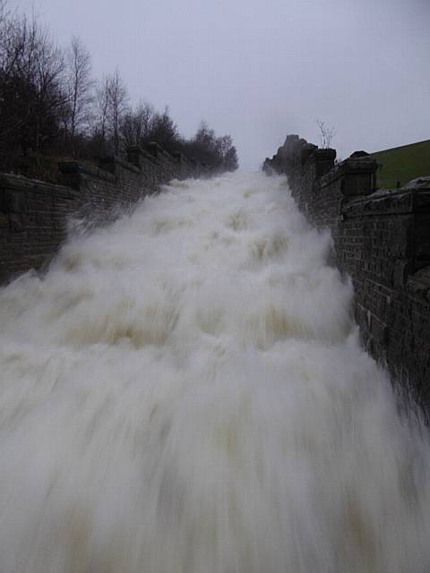 At Watergrove reservoir, gallons of water gushing down the recently renovated reservoir overflow 