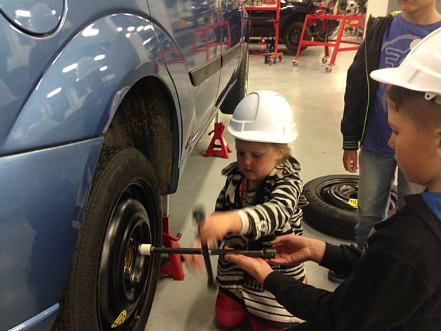 Visitors get to grips with changing a car tyre at Hopwood Hall College’s Summer Fun Day