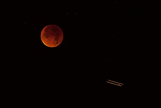 The supermoon lunar eclipse seen from Castleton as a plane passes