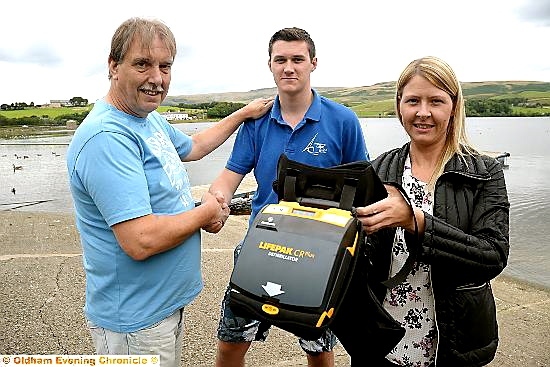 Robert Dunn and daughter Emma thank Joe Ready, with the defibrillator