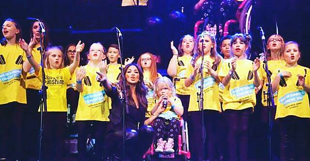 Ella Chadwick and Nicole Scherzinger performing with The Rays of Sunshine Charity Wish Choir at SSE Arena, Wembley