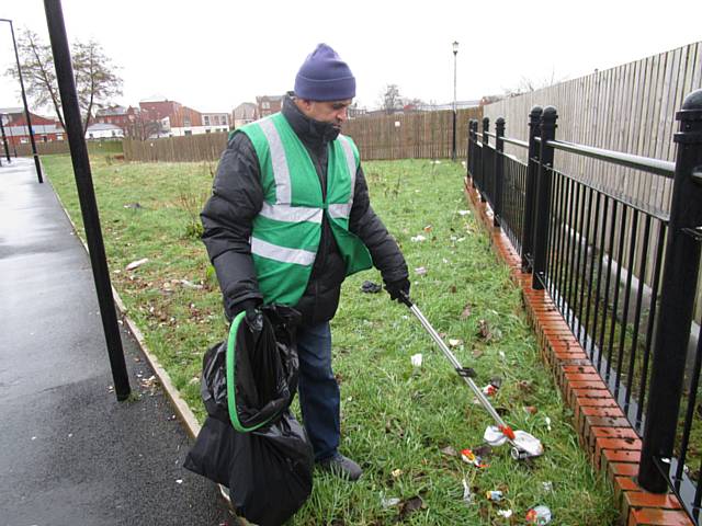 Rochdale Environmental Action Group cleaning the open area near the tram tracks on Drake Street