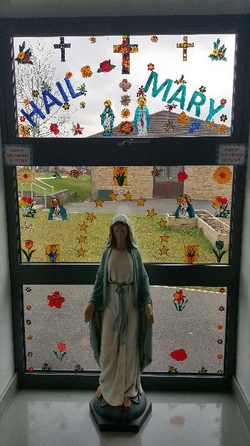 Colourful backdrop on the window behind Our Lady’s statue in the entrance to Caritas near the DEN