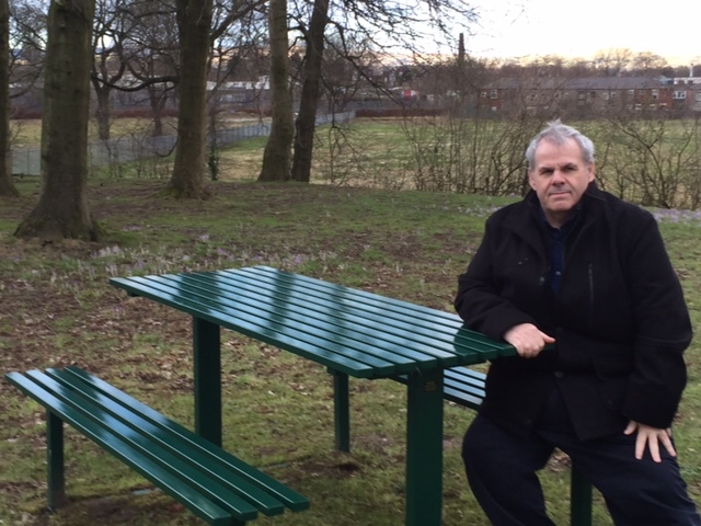 Councillor Farnell takes a seat at one of the new disabled-friendly benches in Balderstone Park