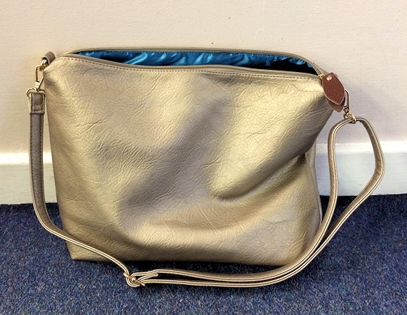 Have you found or seen a brown leather bag with a shoulder strap or a metallic/gold shopping bag, like the one in the photo