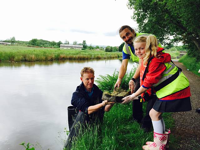 Children from St Edwards Church of England Primary School with volunteers from the Canal & River Trust planting Luronium in Rochdale Canal