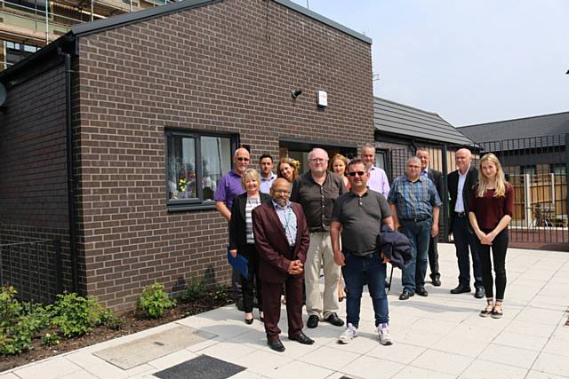 RBH employees, local residents and community representatives outside the new homes at Lower Falinge