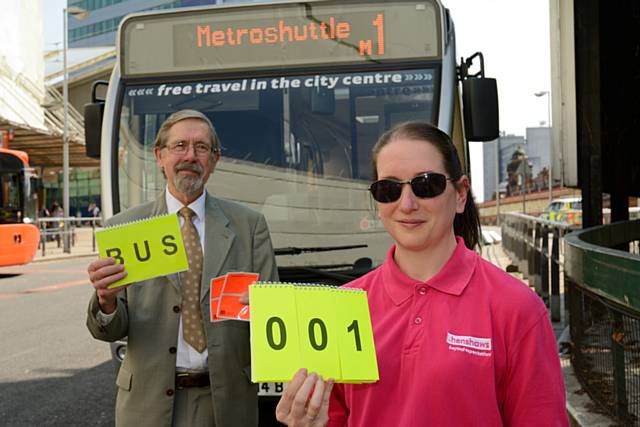 Councillor Andrew Fender, Chairman of the TfGM Committee and Gail Brett, from the charity Henshaws, demonstrate the orange pass wallets and bus hailers