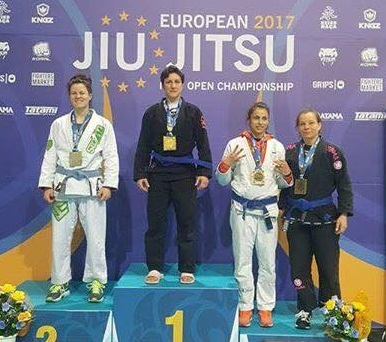 Sophie Cox on the podium after winning gold, European Masters blue belt lightweight