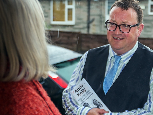 Andy Kelly talking to a resident (in the rain!)