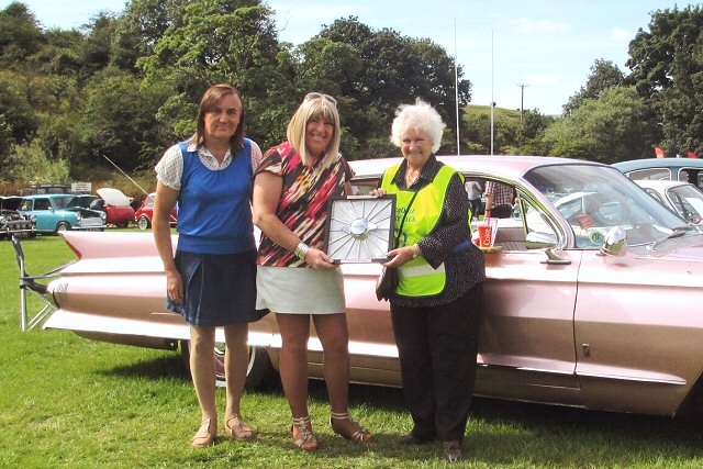 Rochdale Rotary President Ann Stott presenting the Jaguar Car wheel trim trophy to owners of  best car in show