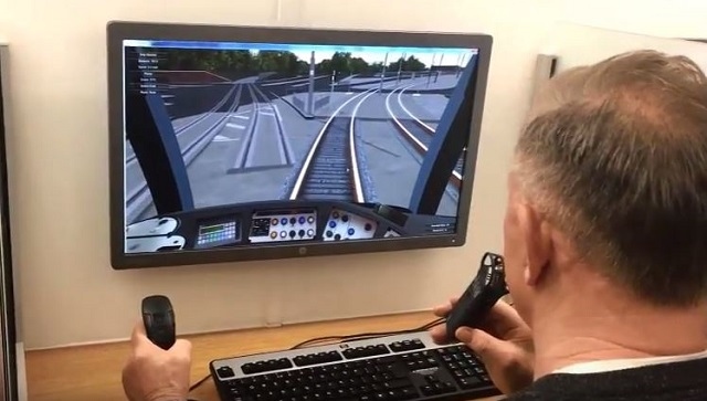 BBC Radio Manchester DJ Mike Sweeney attempting the tram driving simulator at the Metrolink Silver Jubilee event earlier this year