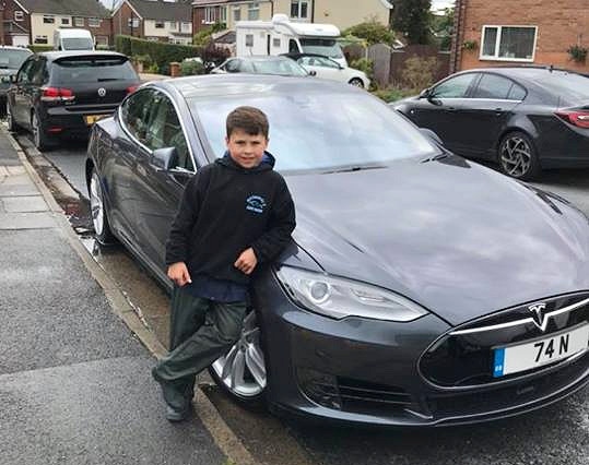 Nathaniel, with his favourite car: a Tesla